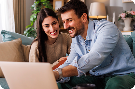 Casal utiliza notebook em casa para acessar atendimento online.