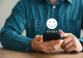 Pessoa avaliando serviço pelo celular, com ícones de satisfação e estrelas de avaliação.